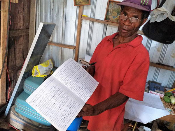 Awi Manag, the main Amam translator, showing the translation he completed by hand after his computer died